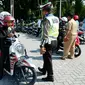 Polisi lalu lintas memberhentikan pengemudi sepeda motor dalam razia pajak kendaraan di Pekanbaru. (Liputan6.com/M Syukur)