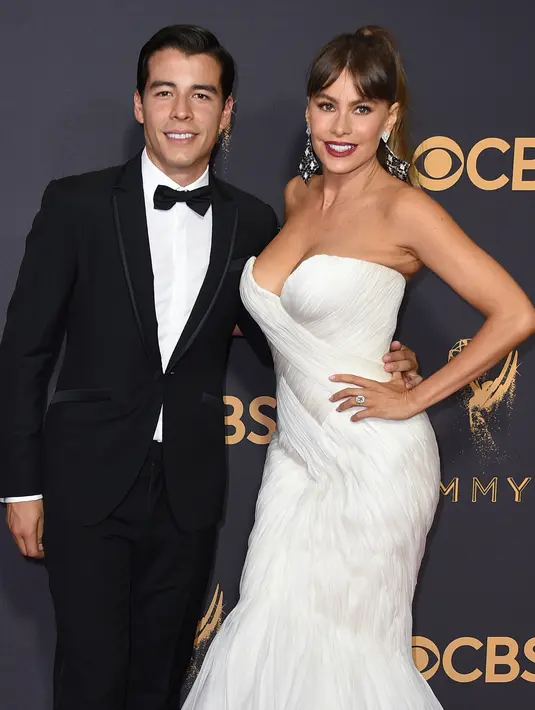 Aktris Sofia Vergara didampingi Manolo Gonzalez Vergara berpose untuk fotografer di karpet merah Emmy Awards 2017 di Los Angeles, Minggu (17/9). Keduanya bahkan lebih terlihat seperti pasangan adik-kakak daripada ibu dan anak. (Jordan Strauss/Invision/AP)