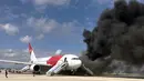Kepulan asap keluar dari pesawat Boeing 767-200ER milik maskapai Dynamic International Airways yang terbakar saat akan lepas landas di Bandara Fort Lauderdale, Florida, Kamis (29/10). 15 orang terluka akibat kejadian tersebut. (AFP PHOTO/Andres Gallego)