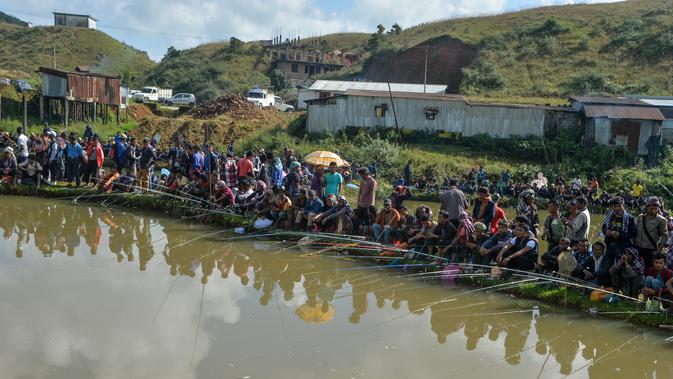 Para peserta pria mengikuti kompetisi memancing di sebuah kolam dekat desa Weilei di Negara Bagian Meghalaya, timur laut India, Sabtu (21/9/2019). Ratusan peserta berpartisipasi dalam kompetisi yang memperebutkan sejumlah hadia tersebut. (DIPTENDU DUTTA / AFP)
