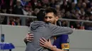 Megabintang Barcelona Lionel Messi dipeluk seorang penyusup yang masuk ke lapangan saat laga lanjutan penyisihan Grup D Liga Champions melawan tuan rumah Olympiakos, Rabu (1/11). Penyusup itu diketahui seorang fans berat Barcelona (AP/Thanassis Stavrakis)