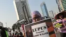 Beragam tulisan dibawa saat aksi memperingati Hari Lupus di Car Free Day, Bunderan HI, Jakarta, Minggu (10/5/2015). Kampanye ini mensosialisasikan kepada masyarakat tentang penyakit lupus. (Liputan6.com/Herman Zakharia)