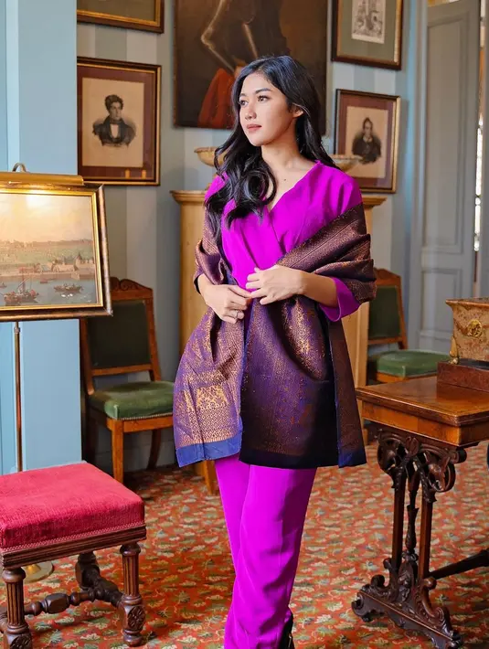 Di sini Erina tampil dengan jumpsuit berwarna ungu polos. Penampilannya semakin elegan dengan kaing songket yang disampirkan di lengannya. Foto: Instagram.