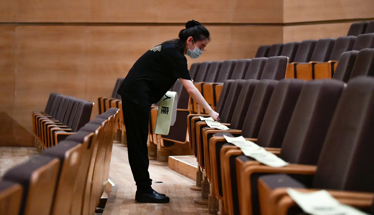 Seorang staf memasang instruksi jaga jarak di kursi-kursi penonton di Tianjin Grand Theater di Tianjin, China pada 28 Juli 2020. Gedung pertunjukan teater itu telah memulai proses disinfeksi menyeluruh selama sepekan sejak Senin (27/7) sebelum dibuka kembali untuk pengunjung. (Xinhua/Sun Fanyue)