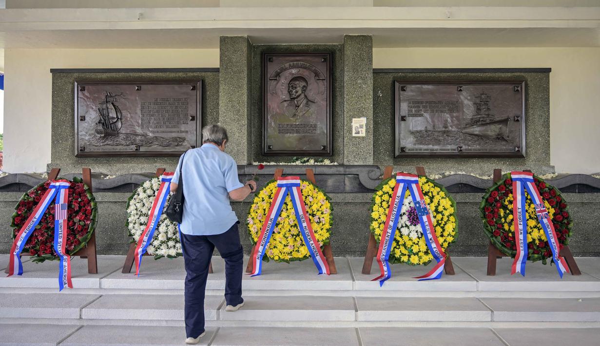 Seorang pria meletakkan bunga di monumen Karel Doorman saat peringatan 84 tahun Pertempuran Laut Jawa di pemakaman perang Belanda Ereveld di Surabaya, Jawa Timur, pada Jumat 27 Februari 2026. 27 Februari 1942, sebuah pertempuran laut terbesar dalam sejarah Perang Dunia II di Pasifik terjadi di wilayah Indonesia. (JUNI KRISWANTO/AFP)