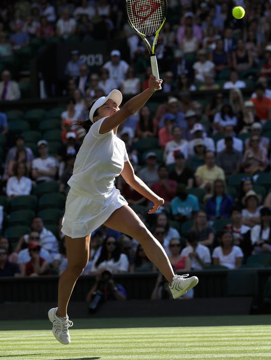 Petenis asal Jepang, Kurumi Nara berusaha mengembalikan bola pukulan Petenis Rumania Simona Halep saat bertanding pada hari kedua tunggal putri Kejuaraan Tenis Wimbledon di London, (3/7). (AP Photo / Ben Curtis)