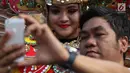 Pengunjung berselfie dengan kelompok seni budaya Kalimantan Selatan saat pelaksanaan car free day di Jakarta, Minggu (1/7). Pawai tersebut diadakan untuk mengenalkan budaya Kalimantan Selatan kepada masyarakat. (Liputan6.com/Immanuel Antonius)