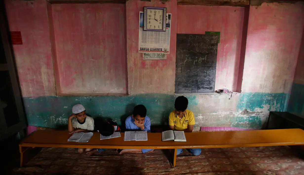 Anak-anak Kashmir saat menghadiri kelas pembacaan Al-Quran di sebuah madrasah lokal selama bulan Ramadan di Srinagar, Kashmir yang dikuasai India, (30/5). (AP Photo / Mukhtar Khan)