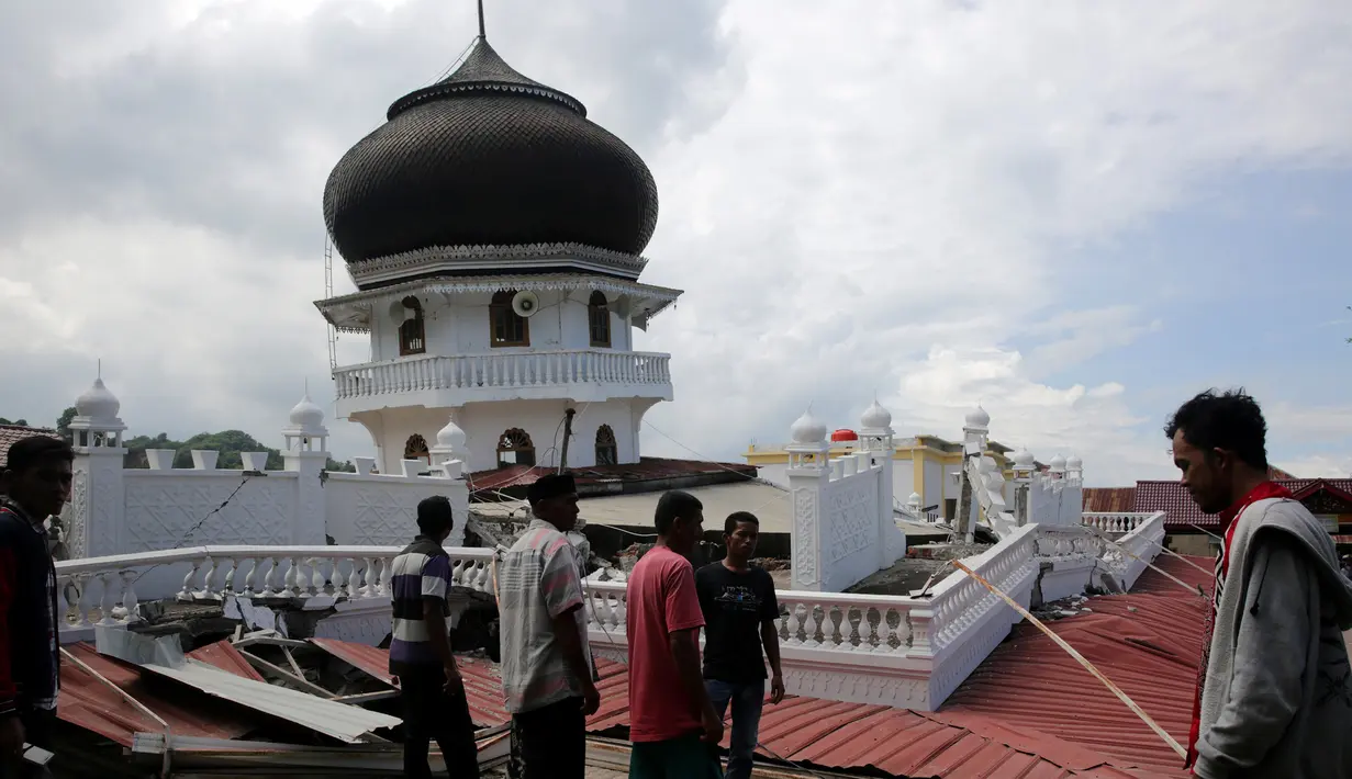 Sejumlah orang melihat kondisi masjid yang runtuh usai gempa di Meuredu, Pidie Jaya, Aceh, Rabu (7/11). Selain meruntuhkan bangunan, gempa bumi berkuatan 6,4 SR ini telah menelan banyak korban jiwa. (Antara Foto / Irwansyah Putra / via REUTERS)