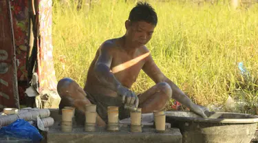 Seorang pekerja menambahkan bubuk mesiu ke dalam silinder karton untuk membuat kembang api di dalam pondok di kota Bocaue, provinsi Bulacan, Filipina, (26/12/2015) Desember 2015. (REUTERS/Romeo Ranoco)