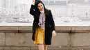 Gaya Ochi saat tengah berlibur di London, Inggris ini pun terlihat kasual. Dirinya hanya mengenakan dress berwarna kuning dengan sneakers hitam senada dengan coat yang dikenakan. (Liputan6.com/IG/@ochi24)