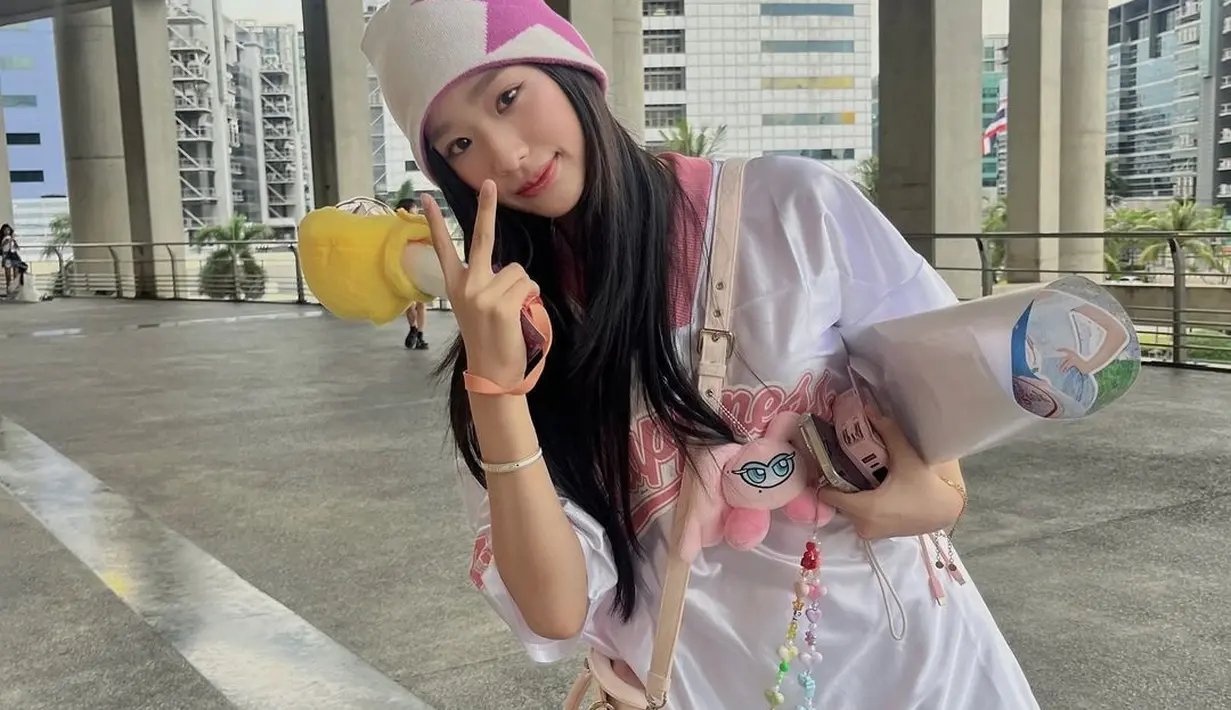 Y2K Coded! Tiru gaya manis Tontawan kenakan boxy t-shirt dengan mini skirt, beanie, sling bag, dan beberapa doll charm warna-warni. [@tontawan].