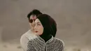 Outfit Dinda Hauw sangat cocok dengan suasana gurun pasir yang dramatis, memberikan nuansa Timur Tengah yang kental. Karena itu, banyak netizen menyebutnya mirip warga lokal Madinah. Kepercayaan dirinya saat menunggang kuda juga patut diacungi jempol. (Liputan6.com/IG/@rey_mbayang)