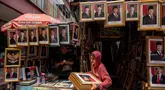 Seorang pembeli membawa foto presiden terpilih Indonesia Prabowo Subianto dan wakil presiden terpilih Gibran Rakabuming Raka menjelang pelantikan mereka pada 20 Oktober, di sebuah toko di Jakarta pada 19 Oktober 2024. (JUNI KRISWANTO/AFP)