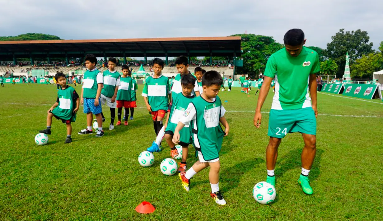 Dimas Drajad (kanan) memberikan football clinic kepada lebih dari 150 anak-anak usia sekolah dasar di stadion Mini Universitas Sumut, Minggu (14/2/2016). Football clinic merupakan salah satu kegiatan di MILO Football Championship 2016. (Foto:Istimewa)