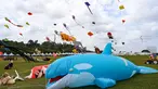 Para peserta menerbangkan layang-layang mereka selama Festival Layang-Layang Dunia Pasir Gudang ke-25 di Bukit Layang-Layang di negara bagian Johor, Malaysia, pada 24 Februari 2023. - Festival ini dilanjutkan kembali setelah 3 tahun terhenti karena pandemi Covid-19. (AFP/Roslan Rahman)