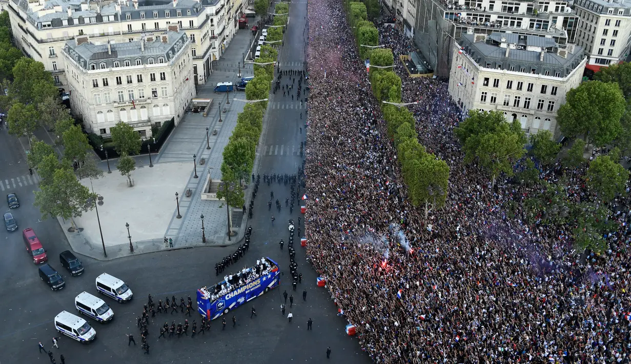 Jutaan fans menyambut kedatangan timnas Prancis di Champs-Elysee avenue, Paris, (16/7/2018). Sambutan meriah tersebut adalah bagian dari perayaan keberhasilan Prancis meraih trofi Piala Dunia 2018. (AFP/Bertrand Guay)