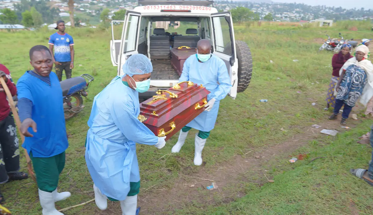 Petugas yang mengenakan pakaian pelindung menurunkan peti mati berisi jenazah balita berusia 3 tahun yang meninggal akibat Ebola saat pemakaman di Bunia, Provinsi Ituri, Kongo timur, Selasa, 18 Agustus 2026. (Foto AP/Dieudonne Dirole)