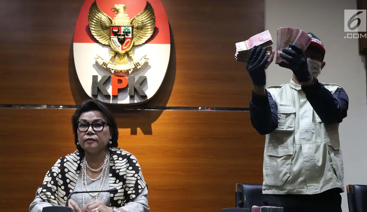 Wakil Ketua KPK, Basaria Panjaitan (kiri) bersama petugas KPK menunjukkan barang bukti hasil OTT terkait pengisian jabatan perangkat daerah di lingkungan Pemkab Kudus, Gedung KPK Jakarta, Sabtu (27/7/2019). KPK menyita barang bukti uang sebesar Rp170 juta. (Liputan6.com/Helmi Fithriansyah)
