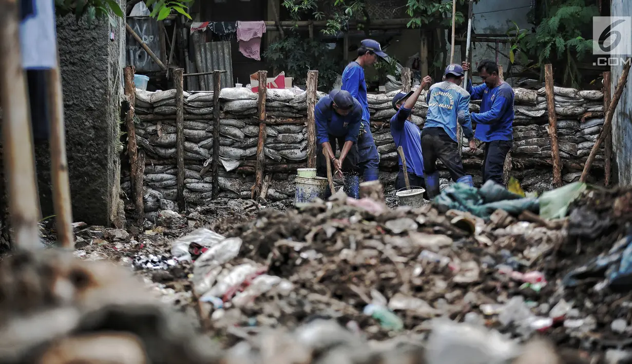 Petugas Suku Dinas SDA Jakarta Selatan membangun turap permanen di lokasi tanggul jebol di Kelurahan Jatipadang, Jakarta, Rabu (16/1). Jebolnya tanggul sempat menyebabkan permukiman warga tergenang air setinggi 30-50 cm. (Liputan6.com/Faizal Fanani)