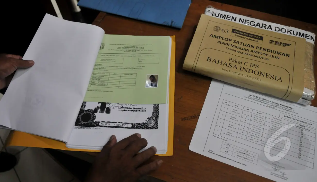 Petugas memeriksa berkas seorang narapidana LP Cipinang yang ikut menjalani UN melalui program Paket C di LP Narkotika Cipinang, Jakarta, Senin (13/4/2015).  Para peserta terlihat bersemangat menjalani UN 2015. (Liputan6.com/Johan Tallo)