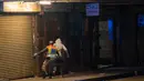 Seorang perwira polisi mengejar seorang pria saat berpatroli di pusat kota Johannesburg, Afrika Selatan, Jumat (27/3/2020). Polisi dan tentara mulai berpatroli beberapa saat setelah Afrika Selatan melakukan Lockdown 21 Hari dalam upaya untuk mengurangi penyebaran Covid-19. (AP Photo/Jerome Delay)