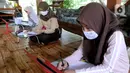 Siswa belajar secara daring menggunakan fasilitas wifi gratis di Perumahan Pondok Mulya I, Beji, Depok, Jawa Barat, Rabu (29/7/2020). Fasilitas tersebut disediakan oleh Sri Wiwoho untuk siswa sekitar perumahan. (merdeka.com/Arie Basuki)