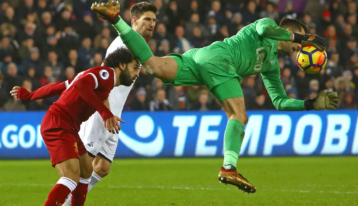 Kiper Swansea City, Lukasz Fabianski (kanan) mengamankan bola dari kejaran pemain Liverpool, Mohamed Salah pada lanjutan Premier League di Liberty Stadium, Swansea, (22/1/2018). Liverpool kalaj dari Swansea 0-1. (AFP/Geoff Caddick)