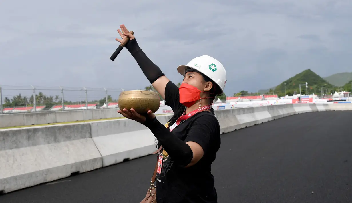 Seorang pawang hujan melakukan ritual saat sesi latihan bebas MotoGP Indonesia di Sirkuit Mandalika, Mandalika, Lombok Tengah, Nusa Tenggara Barat, Jumat (18/3/2022). (AFP/Bay Ismoyo)