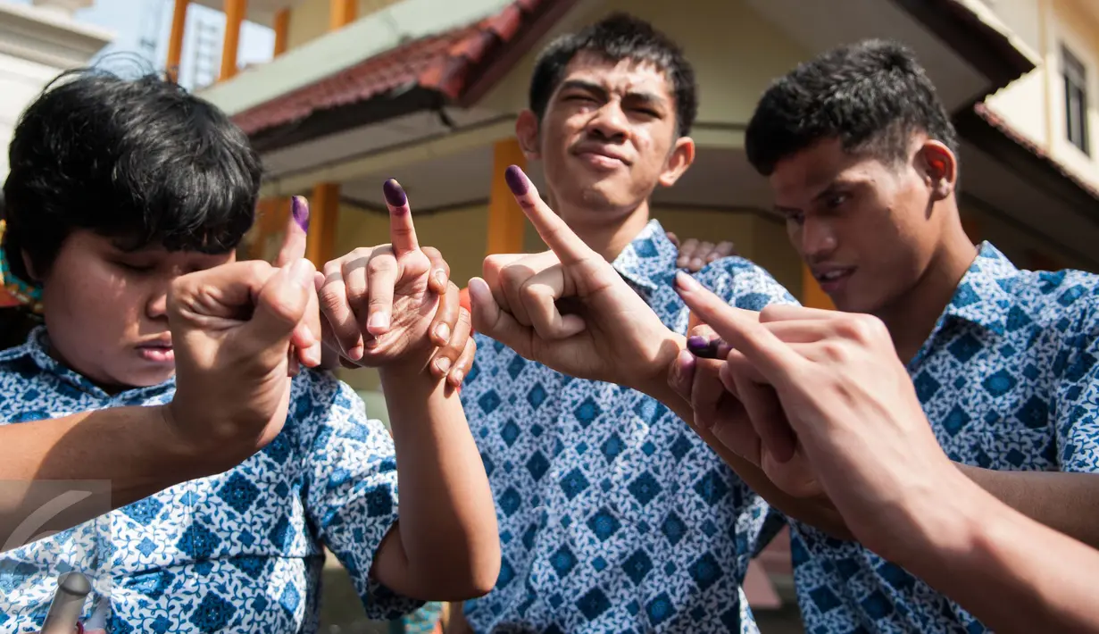 Penyandang disabilitas menunjukan jarinya usai pencoblosan pada Pilkada Putaran kedua di TPS 07 Kelurahan Cawang, Jakarta, Rabu (19/4). Penyandang disabilitas boleh membawa pendamping selama pencoblosan. (Liputan6.com/Gempur M. Surya)
