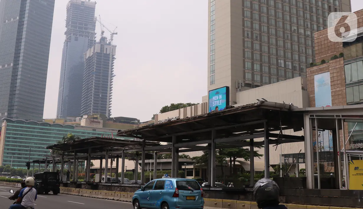 Kendaraan melintas dekat Halte TransJakarta Bundaran HI, Jakarta yang rusak, Jumat (9/10/2020). Demo menolak omnibus law Undang-Undang (UU) Cipta Kerja diwarnai kericuhan dan pembakaran terhadap sejumlah halte Transjakarta. (Liputan6.com/Angga Yuniar)