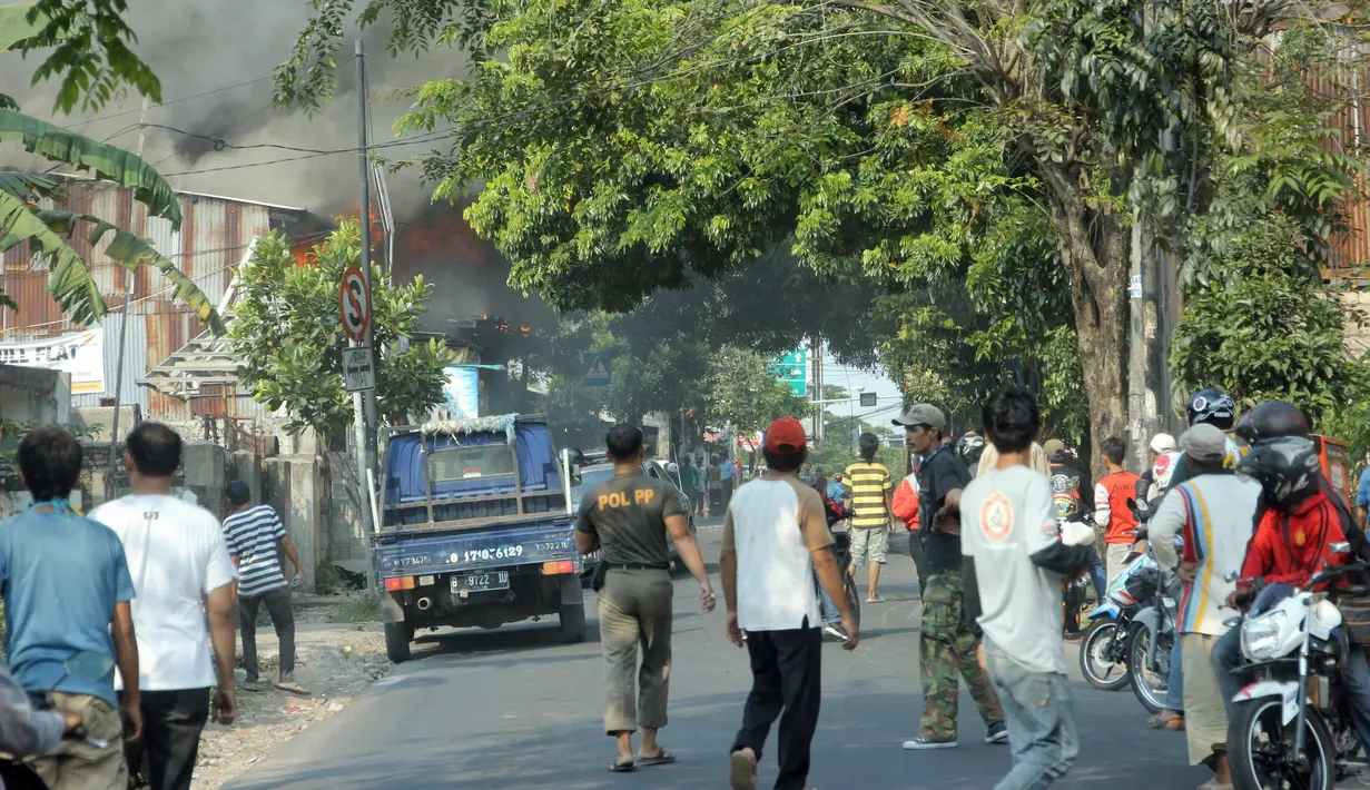 Warga sekitar berhamburan untuk melihat kebakaran yang terjadi pada sebuah toko material di kawasan Grogol, Jakarta, Kamis (21/5/2015). Menurut warga sekitar, api diduga muncul dari lantai dua gudang toko material. (Liputan6.com/Helmi Afandi)
