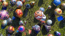 Festival tahunan ini menjadi perayaan budaya untuk memperingati akhir Ramadan dan merayakan Hari Raya Idul Fitri 1447 Hijriah. Tampak dalam foto, pemandangan udara menunjukkan balon udara yang dihiasi motif tradisional sebelum diluncurkan selama festival tahunan yang diadakan untuk merayakan Hari Raya Idul Fitri, di desa Semayu, Wonosobo, Jawa Tengah pada Senin 23 Maret 2026. (DEVI RAHMAN/AFP)