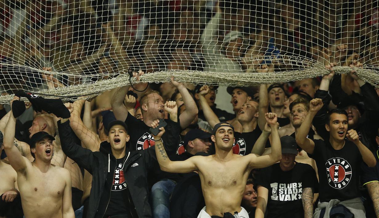 Suporter Ajax Amsterdam melakukan selebrasi usai laga semifinal Liga Europa di Stadion Parc Olympique Lyonnais, Kamis (12/05/2017). Lyon menang dengan skor 3-1. (EPA/Guillaume Horcajuelo)