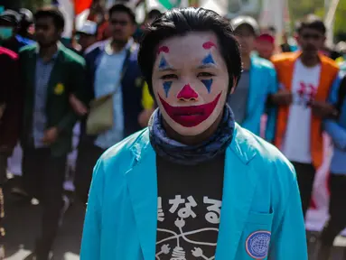 Massa mahasiswa dari BEM Seluruh Indonesia (SI) memakai riasan tokoh Joker dalam unjuk rasa di kawasan Patung Kuda, Jakarta, Senin (21/10/2019). Salah satu tuntutannya adalah meminta Presiden Jokowi menerbitkan Perppu untuk UU KPK yang direvisi. (Liputan6.com/Faizal Fanani)