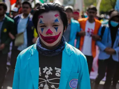 Massa mahasiswa dari BEM Seluruh Indonesia (SI) memakai riasan tokoh Joker dalam unjuk rasa di kawasan Patung Kuda, Jakarta, Senin (21/10/2019). Salah satu tuntutannya adalah meminta Presiden Jokowi menerbitkan Perppu untuk UU KPK yang direvisi. (Liputan6.com/Faizal Fanani)