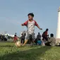 Seorang anak bermain bola di halaman Munomen Nasional (Monas), Jakarta, Kamis (7/7). Libur kedua Lebaran dimanfaatkan warga untuk bekunjung ke lokasi wisata bersama keluarga. (Liputan6.com/Yoppy Renato)