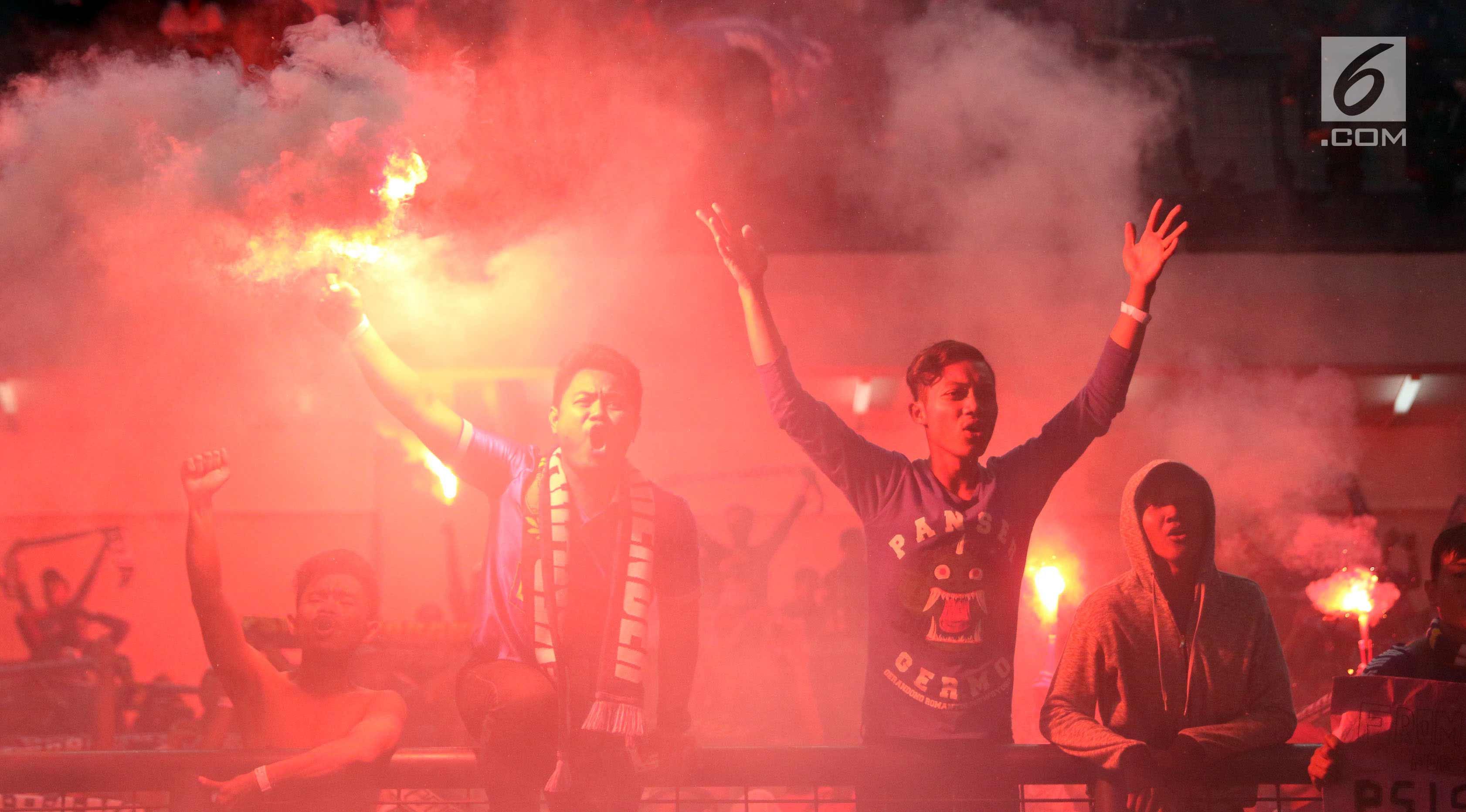 Suporter PSIS menyalakan suar saat merayakan kemenangan timnya melawan Martapura FC di Final tempat ketiga Liga 2 Indonesia di Stadion GBLA, Bandung, Selasa (28/11). PSIS unggul 6-4 dan lolos ke Liga 1 Indonesia. (Liputan6.com/Helmi Fithriansyah)