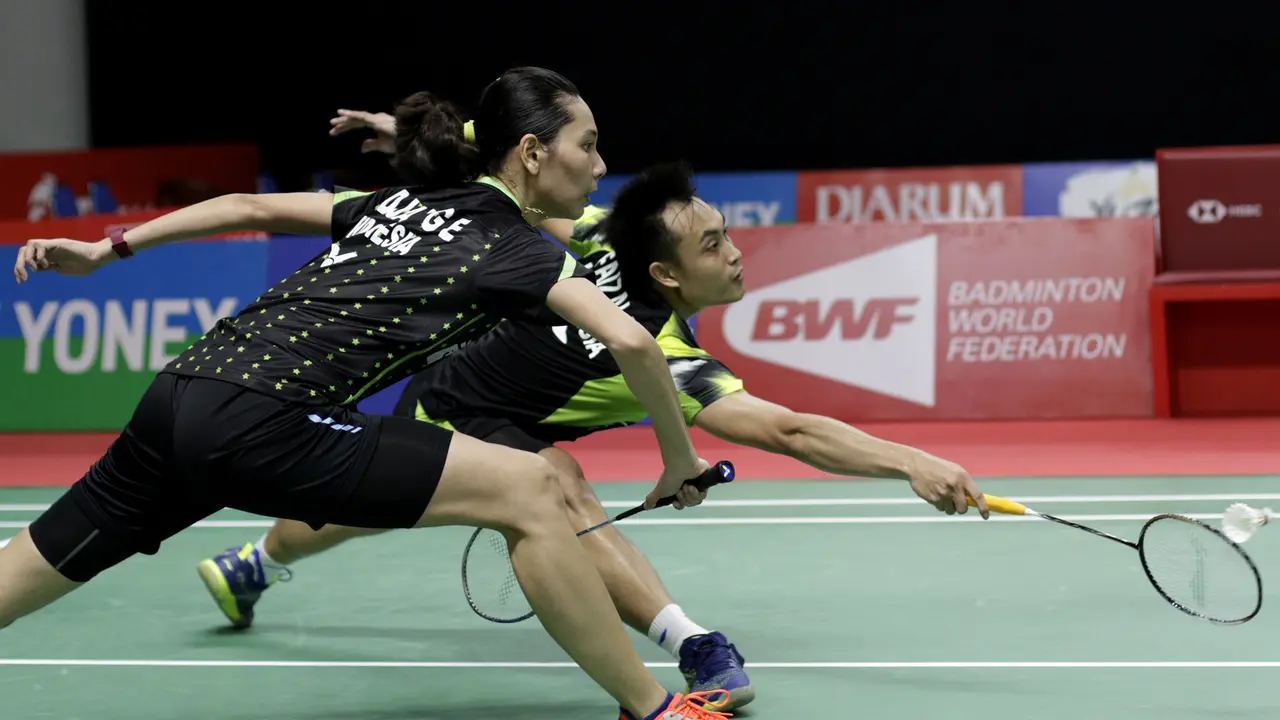 Pebulutangkis Indonesia, Hafiz Faizal / Gloria Widjaja, berusaha mengembalikan kok saat melawan pasangan Malaysia. (Bola.com/M. Iqbal Ichsan)