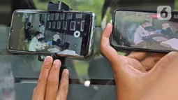 Layar ponsel memperlihatkan gambar Michael Yukinobu Defretes atau Nobu saat melakukan rapid test di Ditreskrimsus Polda Metro Jaya, Jakarta, Senin (4/1/2021). Nobu menjalani pemeriksaan sebagai tersangka dalam kasus video syur bersama Gisella Anastasia atau Gisel. (Liputan6.com/Herman Zakharia)