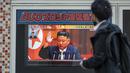 Seorang pria melewati layar televisi yang menampilkan laporan berita tentang peluncuran rudal terbaru Korea Utara dengan gambar pemimpin Korea Utara, Kim Jong Un, di sepanjang jalur pejalan kaki di Tokyo, Kamis (3/11/2022). Korea Utara kembali luncurkan tiga rudal pada Kamis pagi dan salah satu di antaranya terbang di atas Jepang. (Photo by Richard A. Brooks / AFP)