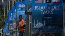 Sebelumnya, pada perundingan pertama yang dilaksanakan di Islamabad, Pakistan, pada 11-12 April 2026, berakhir tanpa kesepakatan. Tampak dalam foto, seorang pekerja berjalan melewati papan reklame menjelang putaran kedua negosiasi antara Amerika Serikat dan Iran, di Islamabad, Pakistan, Senin 20 April 2026. (AP Photo/Anjum Naveed)