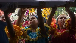 Sejumlah anak-anak mengenakan kostum berpartisipasi dalam acara festival tahunan Panchimalco Flower and Palm Festival di Panchimalco, San Salvador (6/5). Pada perayaan ini, warga setempat menghias daun kelapa dengan bunga. (AFP/Marvin Recinos)