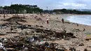 <p>Sampah plastik maupun batang kayu mengotori pantai berpasir putih ini. (SONNY TUMBELAKA/AFP)</p>