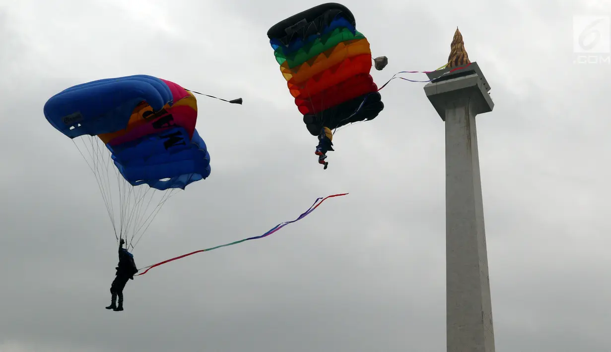 Penerjun wanita dari TNI berada di udara saat atraksi terjun payung pada apel peringatan Hari Kartini 2018 di Silang Monas, Jakarta, Rabu (25/4). Sebanyak 721 personel gabungan prajurit wanita TNI dan Polri melakukan atraksi. (Liputan6.com/Johan Tallo)