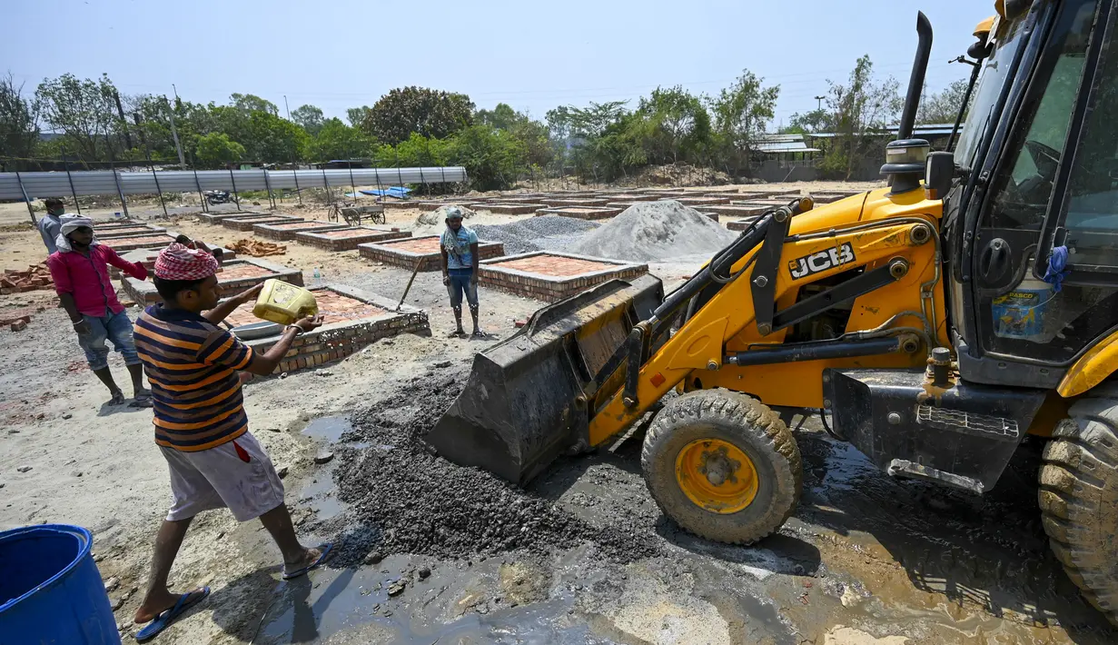 Para buruh bekerja membangun tempat kremasi di ladang kosong di New Delhi, India, Rabu (5/5/2021). Kasus COVID-19 di India sudah tembus angka 20 juta. (Money SHARMA/AFP)