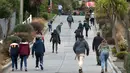 Wisatawan berjalan menyusuri jalanan paling curam di dunia, Baldwin Street, di kota Dunedin, Selandia Baru, 26 Agustus 2017. Jalanan sepanjang 350 meter itu memiliki kemiringan yang ekstrem, yakni 1:2.86 dengan gradien 35 persen. (AP Photo/Mark Baker)