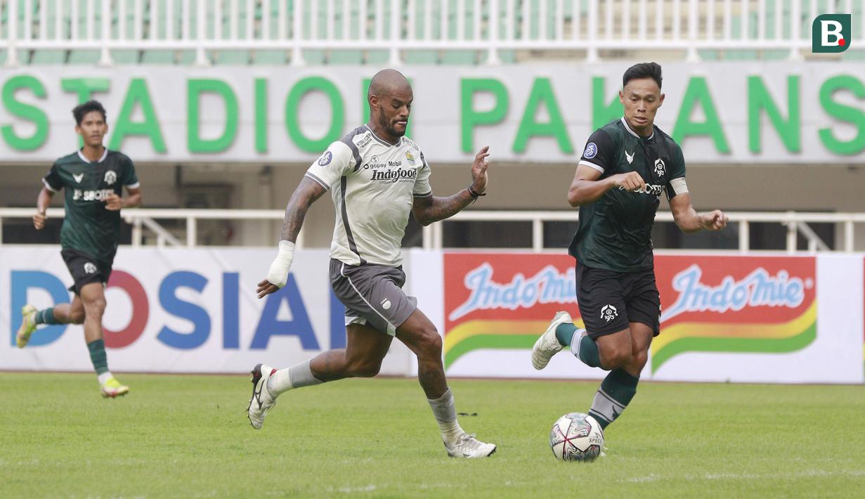 Pemain Persib Bandung, David da Silva, berusaha melewati pemain Persikabo 1973, Andy Setyo, pada laga uji coba di Stadion Pakansari, Bogor, Minggu (27/11/2022). (Bola.com/M iqbal Ichsan)