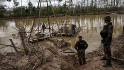 Polisi berdiri dekat mesin penambangan ilegal saat melaksanakan Operation Mercury di Provinsi Tambopata Peru, 1 April 2019. Pemerintah Peru mengerahkan polisi dan tentara untuk mengusir ribuan penambang ilegal yang menebangi hutan Amazon untuk mencari emas. (AP Photo/Rodrigo Abd)