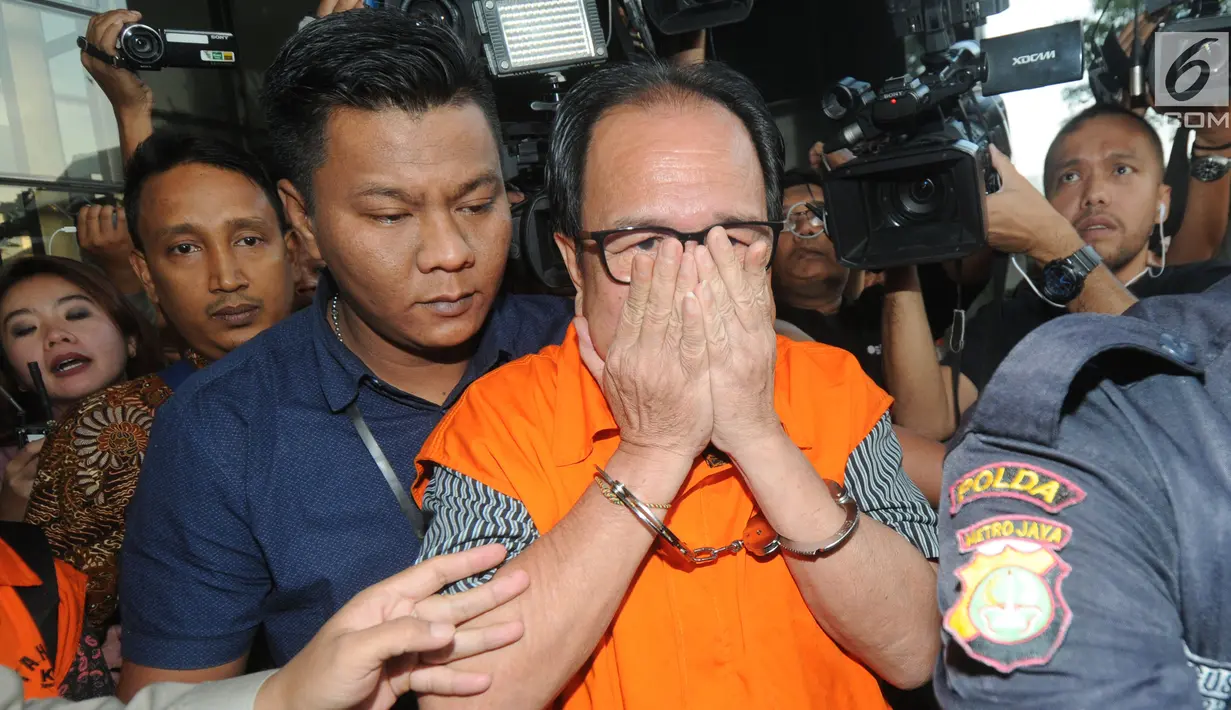 Pihak swasta Joe Fandy Yoesman alias Asiang menutupi wajahnya usai menjalani pemeriksaan di Gedung KPK, Jakarta, Kamis (18/7). Asiang resmi ditahan untuk mempermudah pemeriksaan terkait terkait kasus dugaan suap pengesahan APBD 2017-2018 Provinsi Jambi. (merdeka.com/Dwi Narwoko)